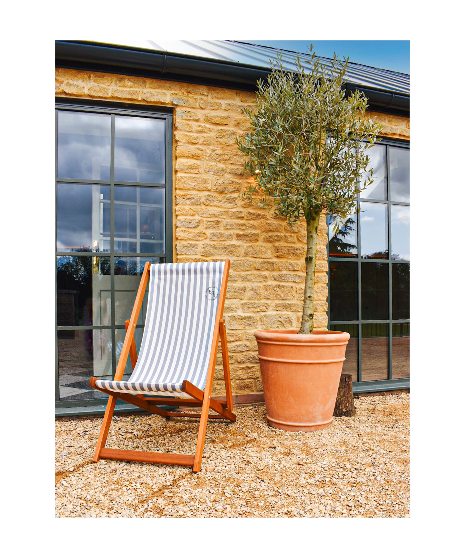 British-made grey stripe deckchair paired with The Betty parasol, offering a stylish and comfortable outdoor seating option for relaxation.