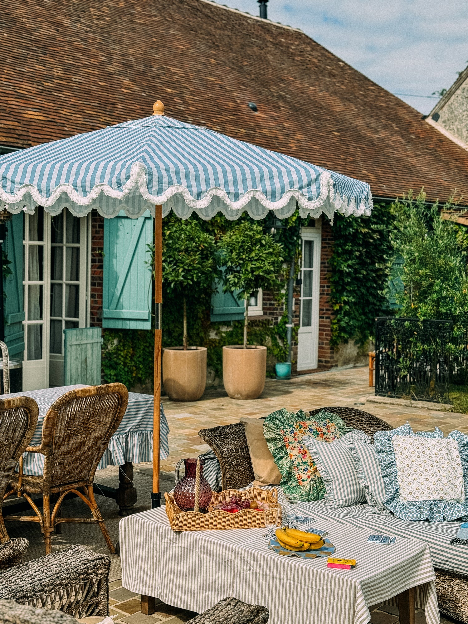 Rupert blue striped parasol with wavy fringed edge and durable frame, perfect for garden or patio. Patio umbrella tablescape.