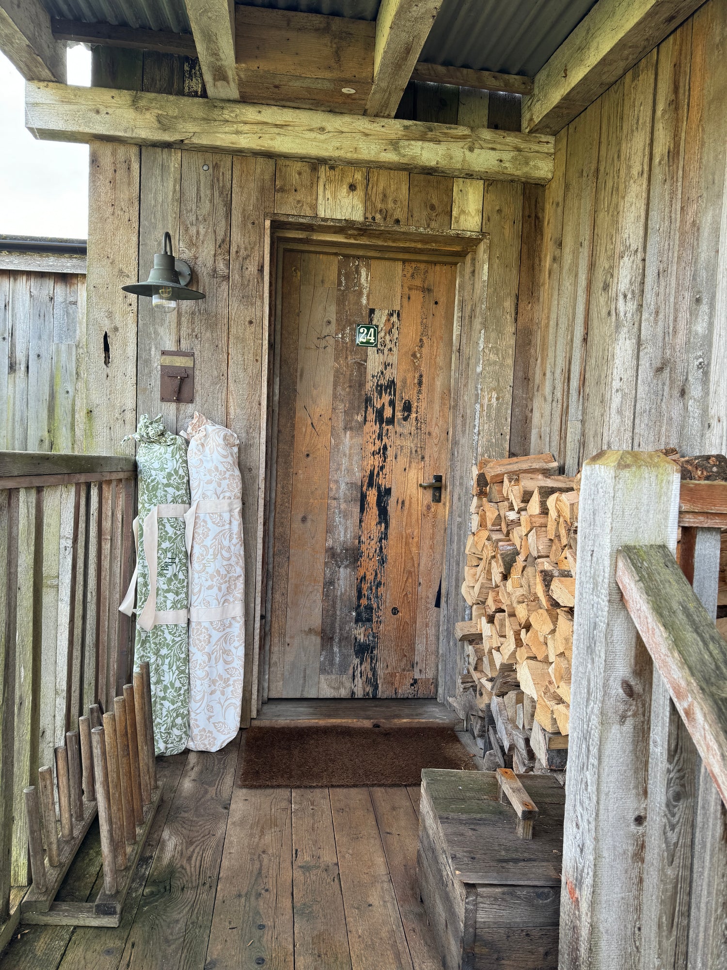 Bridget olive green parasol with natural cotton fringing, floral inner pattern, wooden frame, adjustable positioning, collapsible design, and matching canvas carry bag.