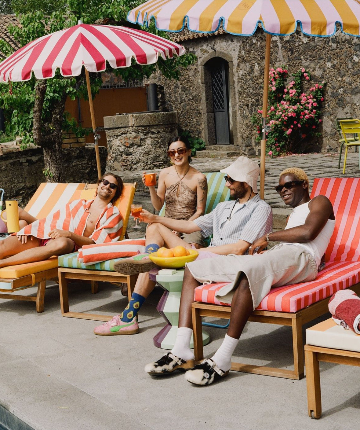 Agnes parasol with nude pink and red stripes, scallop edging, pastel pink trim, wooden frame, adjustable positioning, collapsible design, and matching canvas carry bag.
