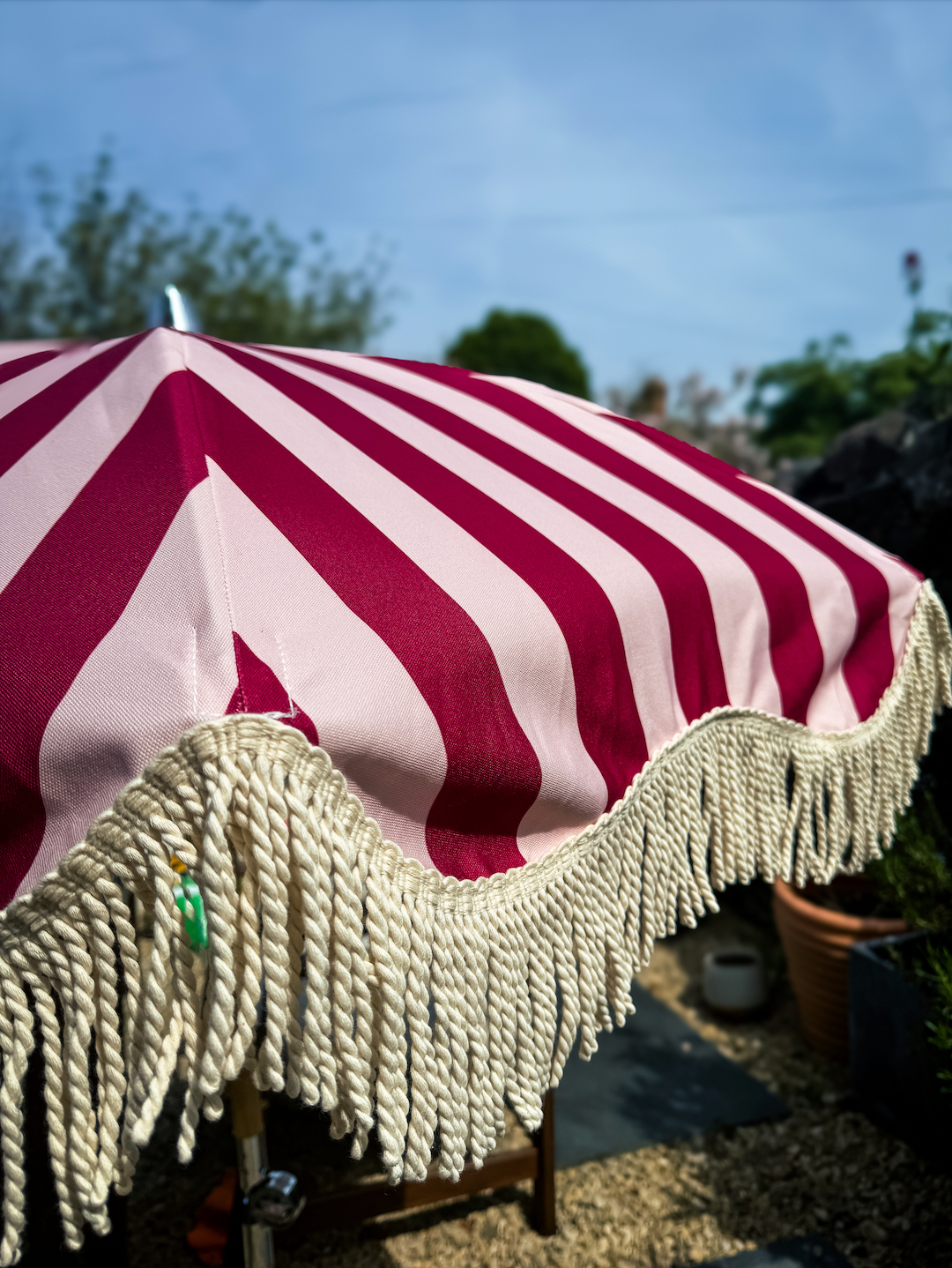 Mini Agnes parasol with natural cotton fringing, wooden frame, adjustable positioning, perfect for children and park outings, includes matching carry bag.