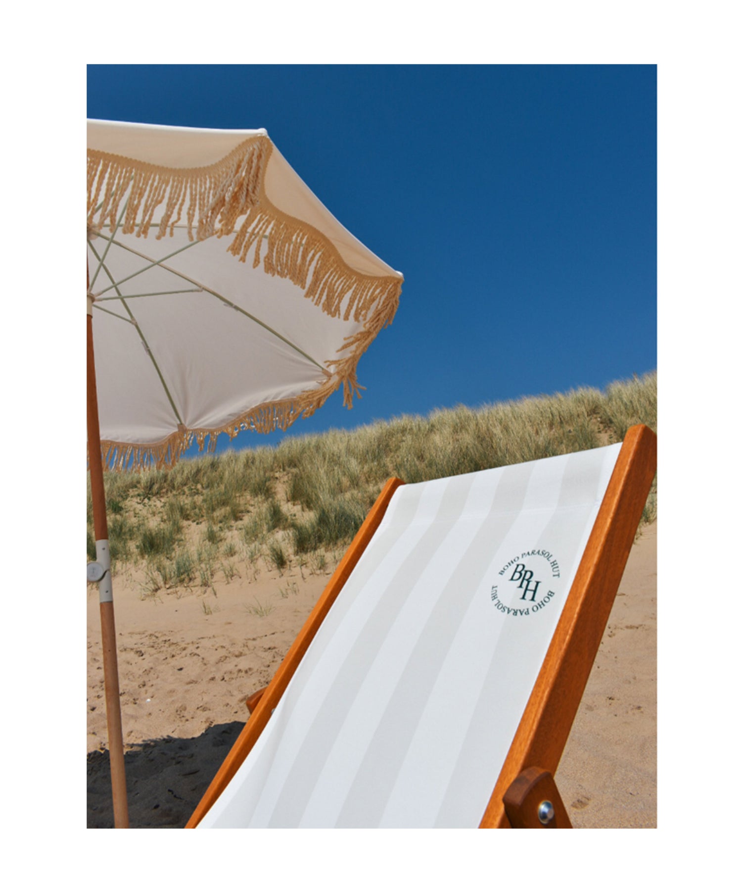 Elegant Cynthia deckchair paired with the matching Cynthia parasol, featuring soft pastel green and white stripes, creating a stylish and comfortable outdoor seating area.