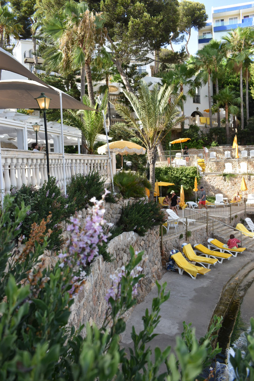 on Sol yellow parasol with natural cotton fringing, featuring a wooden frame and adjustable positioning, perfect for gardens, patios, and outdoor events.