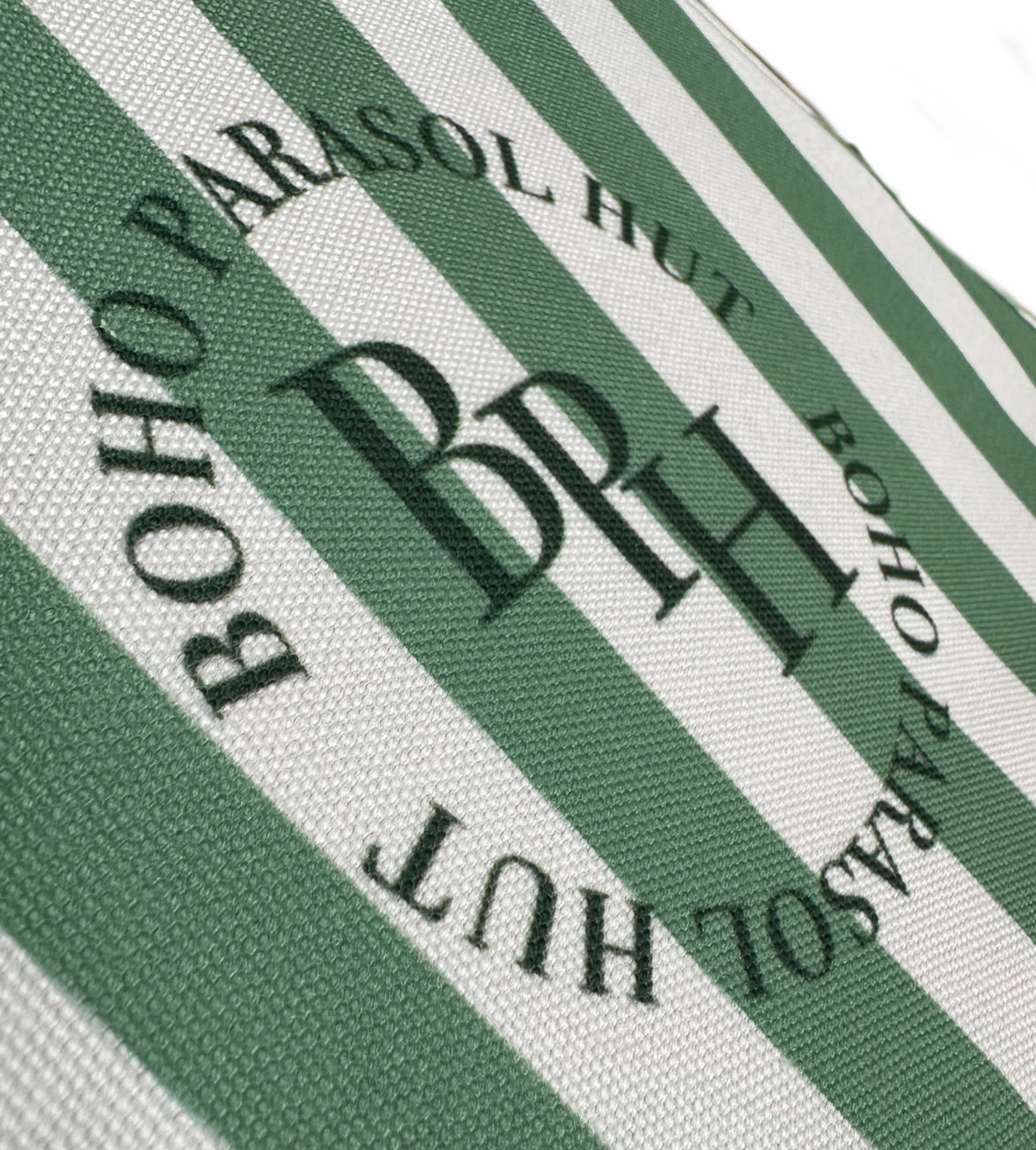 The Theodore luxury parasol with natural cotton fringing, wooden frame pole, adjustable positioning, collapsible design, and matching canvas carry bag.