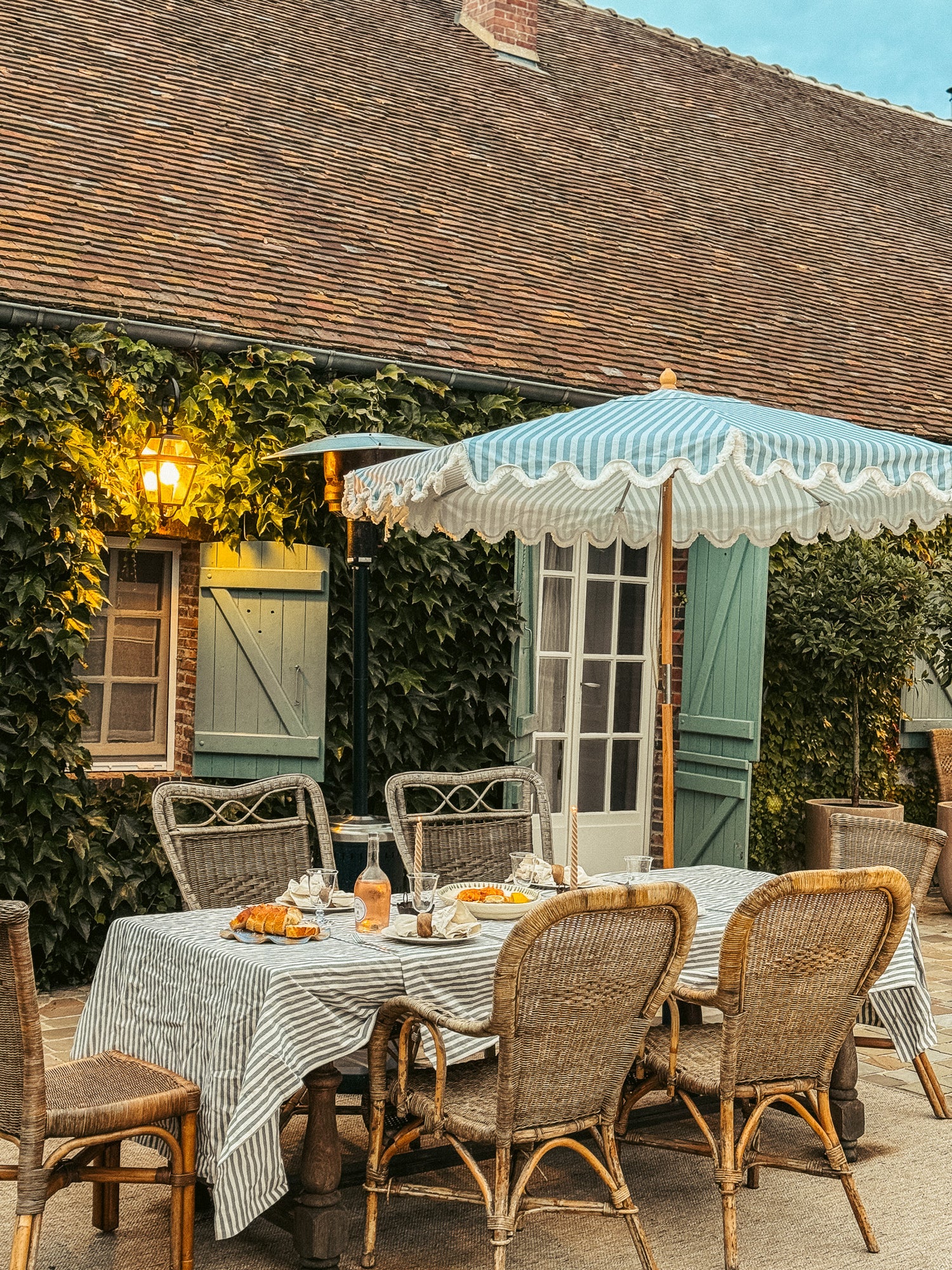 Rupert blue striped parasol with wavy fringed edge and durable frame, perfect for garden or patio. Patio umbrella with tablescape.