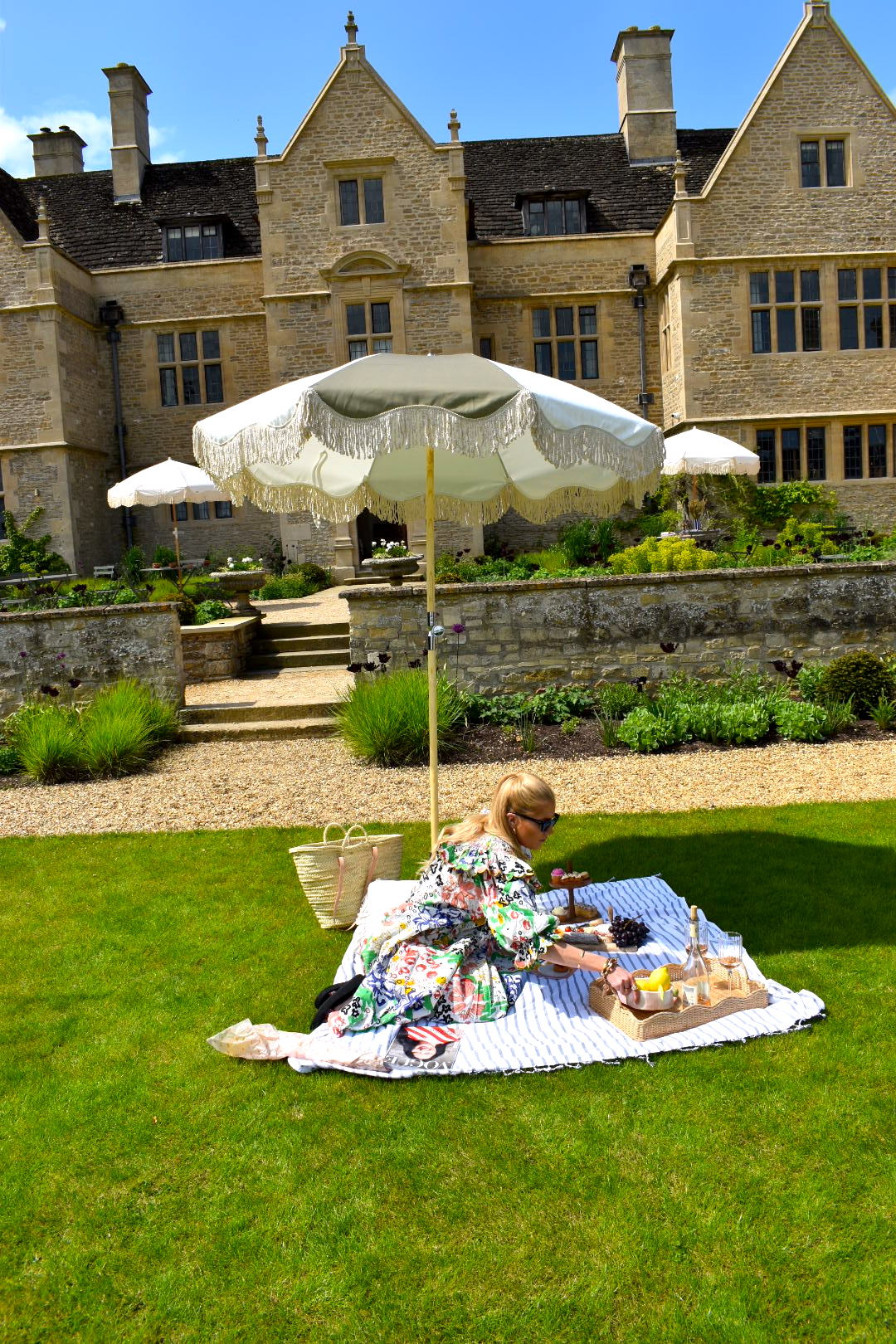 The Salma timeless chic parasol with natural cotton fringing, wooden frame pole, adjustable positioning, collapsible design, and matching canvas carry bag. Picnic umbrella.