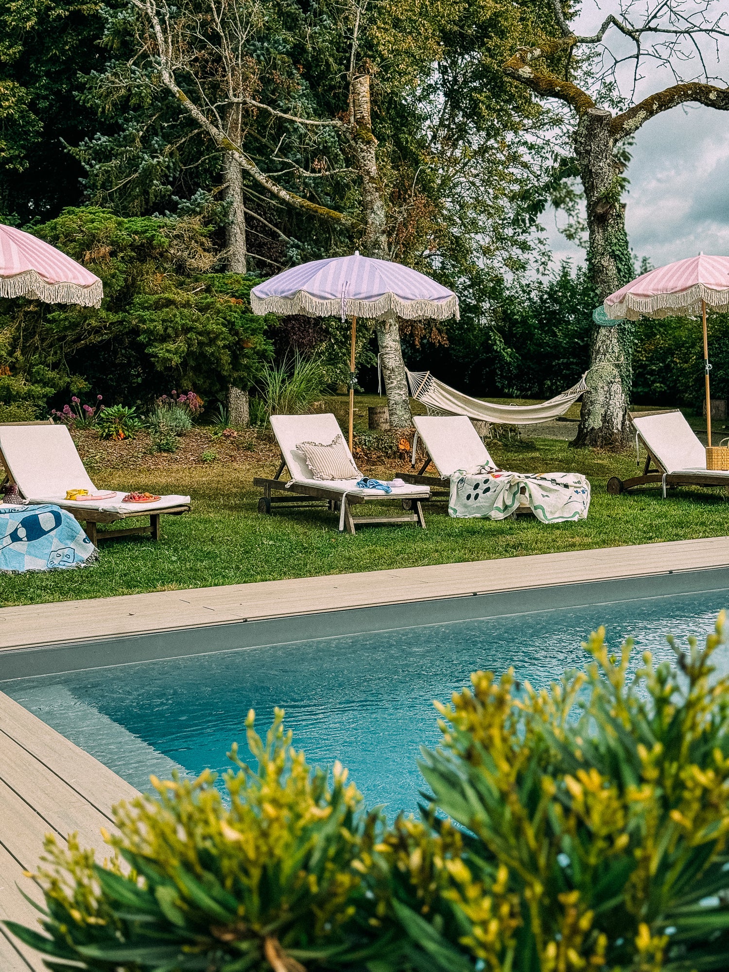 Lilac striped parasol with natural cotton fringing, featuring an authentic wooden frame and adjustable positioning, perfect for gardens, patios, and outdoor events.