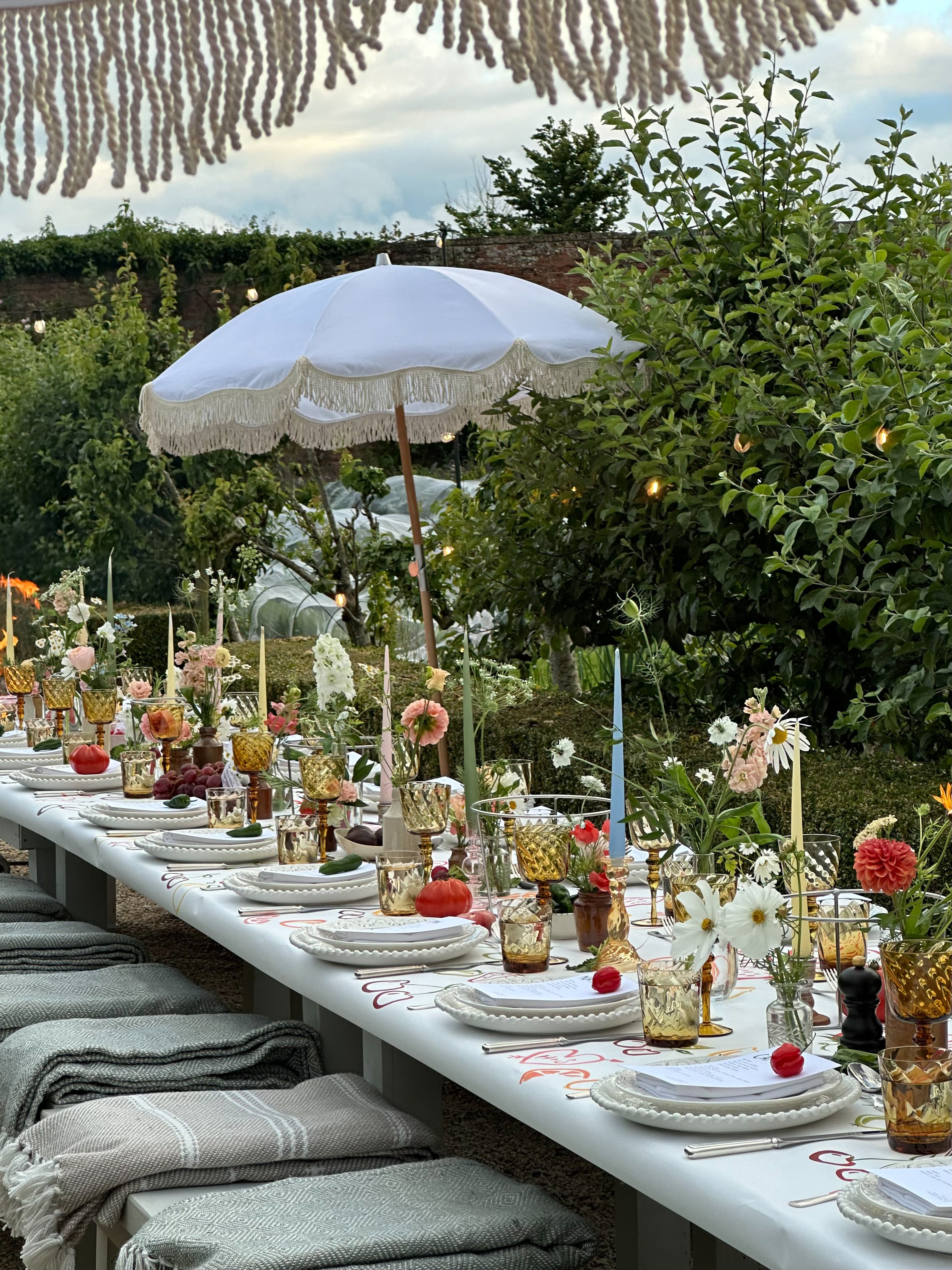 The Cynthia parasol in pastel pink, with natural cotton fringing, elegantly featured in a wedding tablescape at Babbington House, part of the Soho House collection.