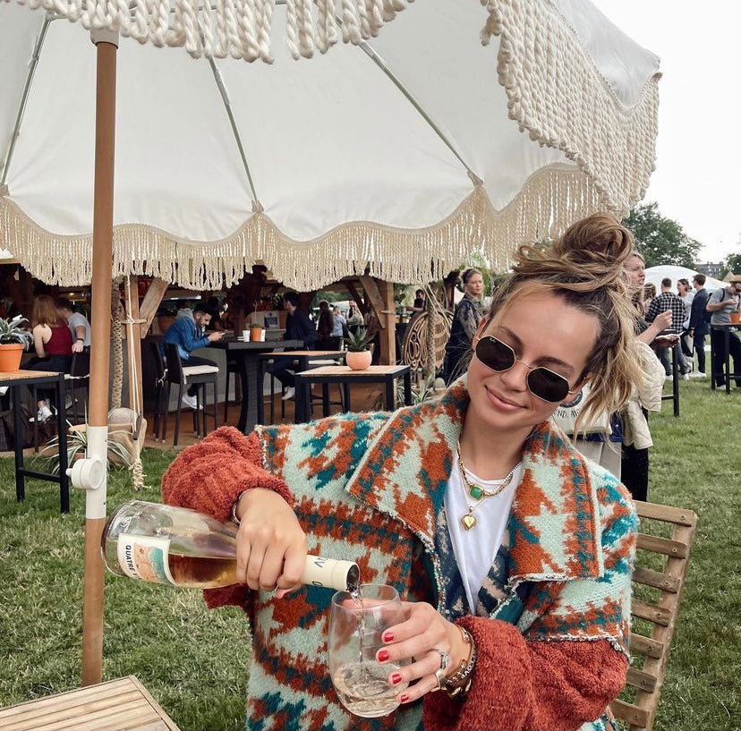 The Cynthia chic pastel parasol with natural cotton fringing, adjustable wooden frame pole, collapsible design, and matching canvas carry bag.