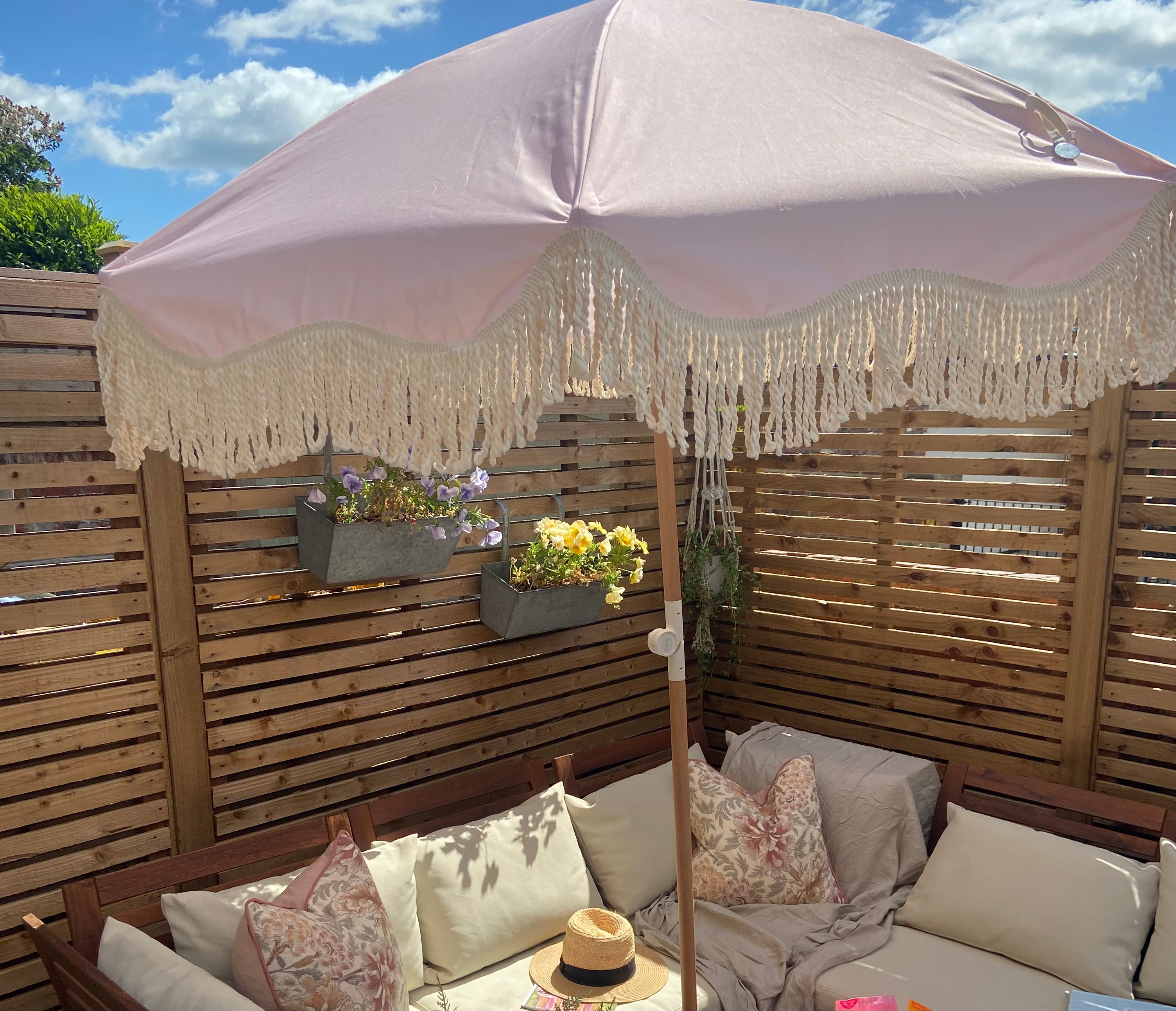 The Penelope pale pink boho chic parasol with natural cotton fringing, adjustable wooden frame pole, collapsible design, and matching canvas carry bag.