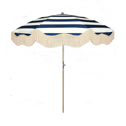 The Hugo timeless chic parasol with natural cotton fringing, wooden frame pole, adjustable positioning, collapsible design, and matching canvas carry bag.