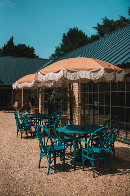 The Brenda timeless chic parasol with natural cotton fringing, adjustable wooden frame pole, collapsible design, and matching canvas carry bag.
