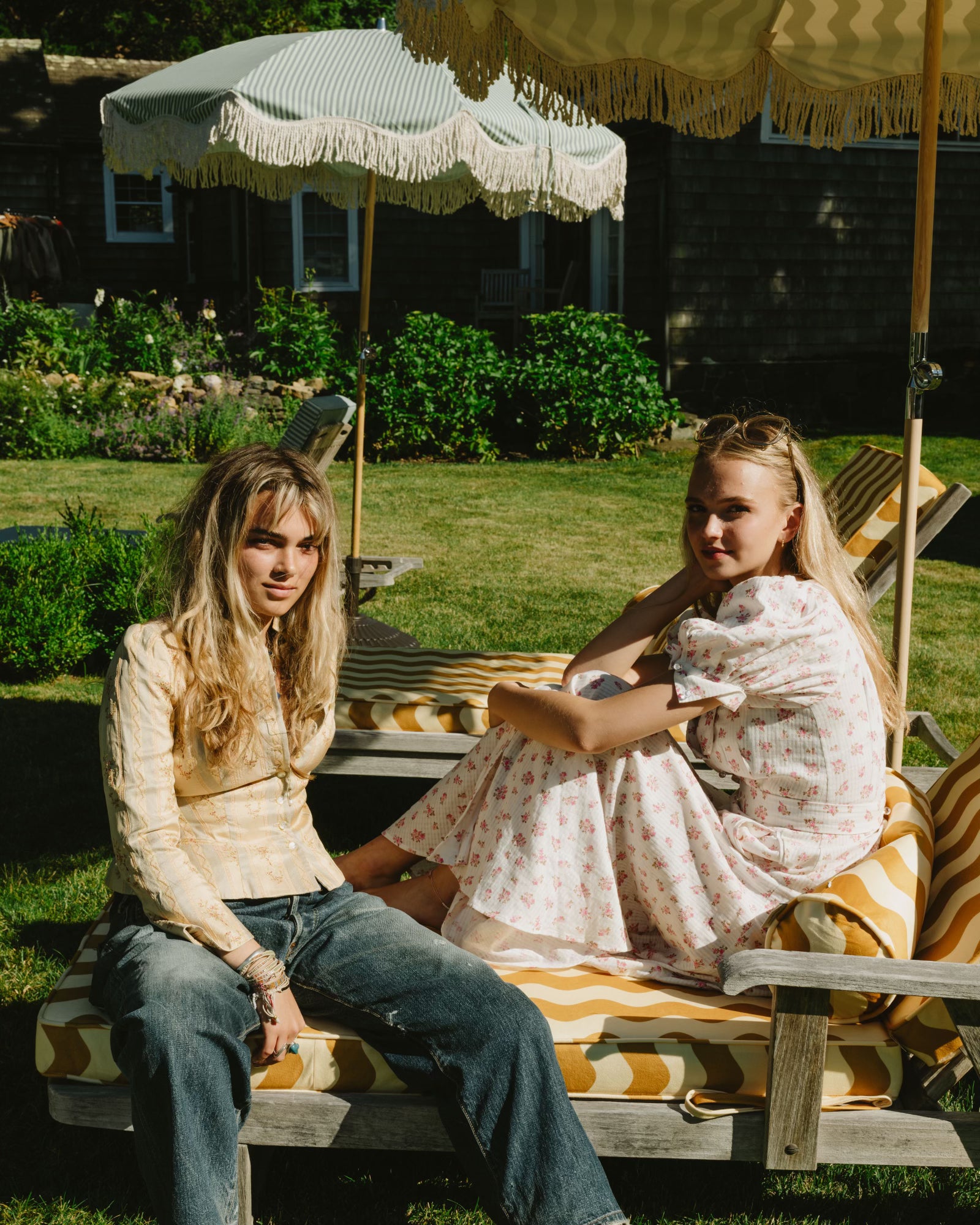 Models enjoying the vibrant Colours of Arley parasol in a luxurious Hamptons garden, showcasing elegant outdoor living with chic style and sun protection.