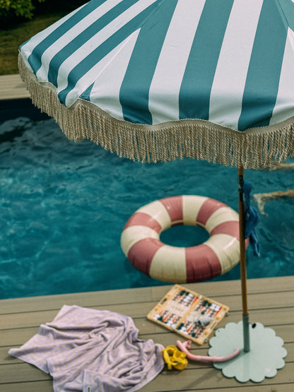 Pastel blue and cream striped parasol with natural cotton fringing, featuring an authentic wooden frame, adjustable positioning, and a collapsible design, perfect for gardens and patios