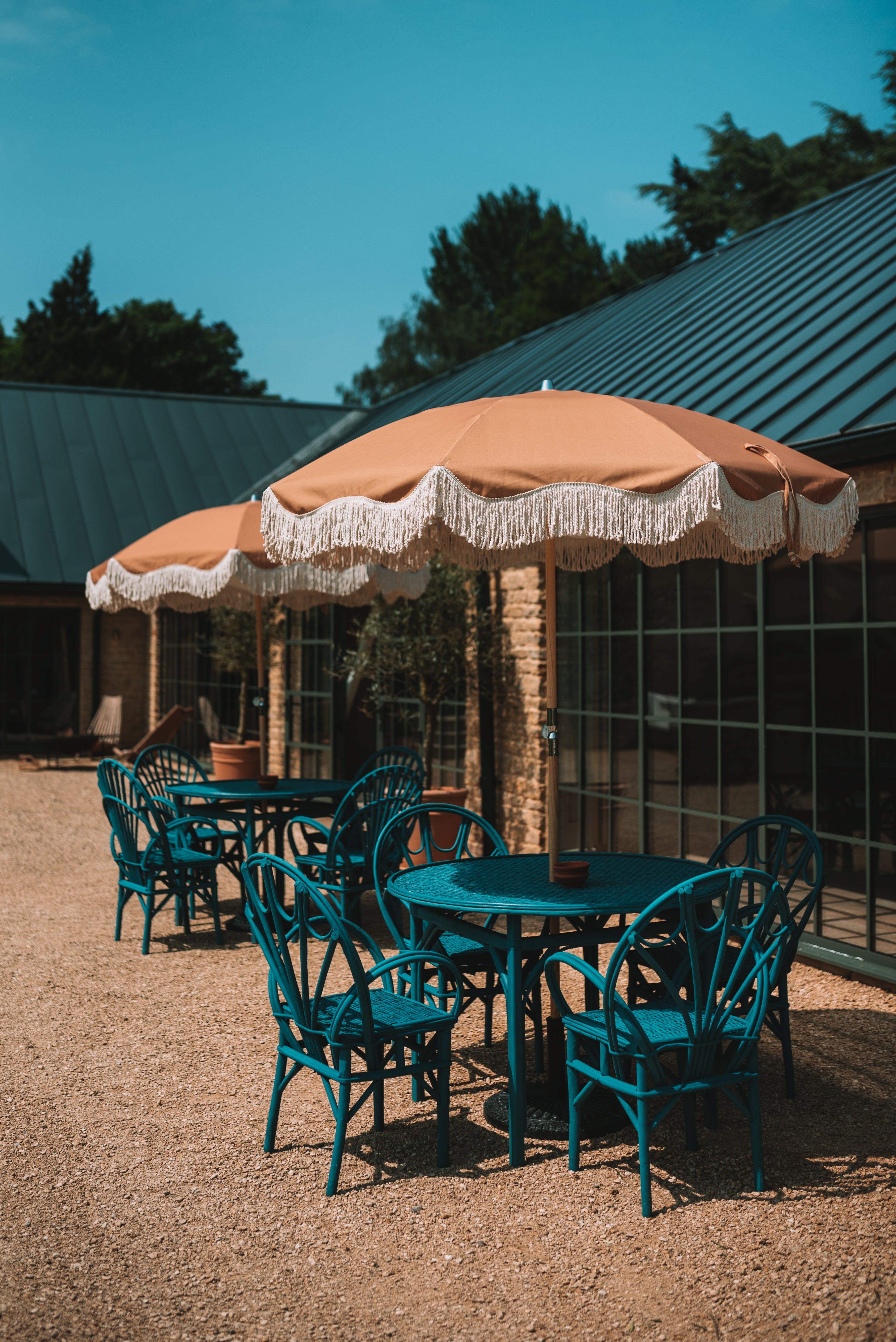Fawn brown parasol styled in a garden setting, bringing timeless elegance to outdoor living