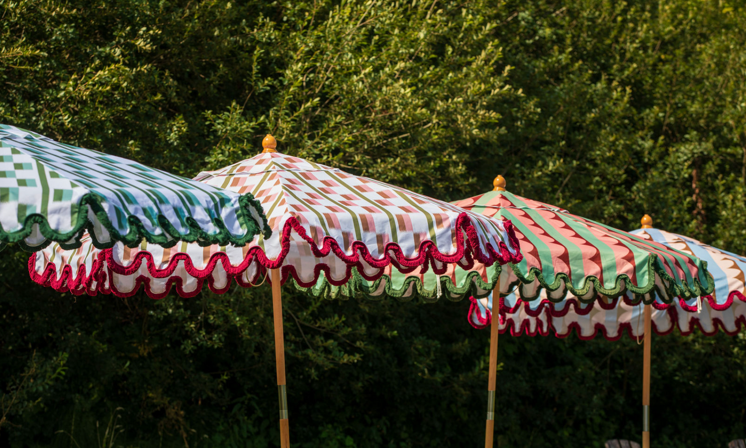 Luxury striped and fringed parasols styled together for design-led garden outdoor living