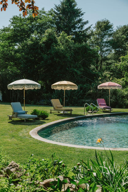 Colourful striped and fringed parasols creating a relaxed poolside outdoor setting